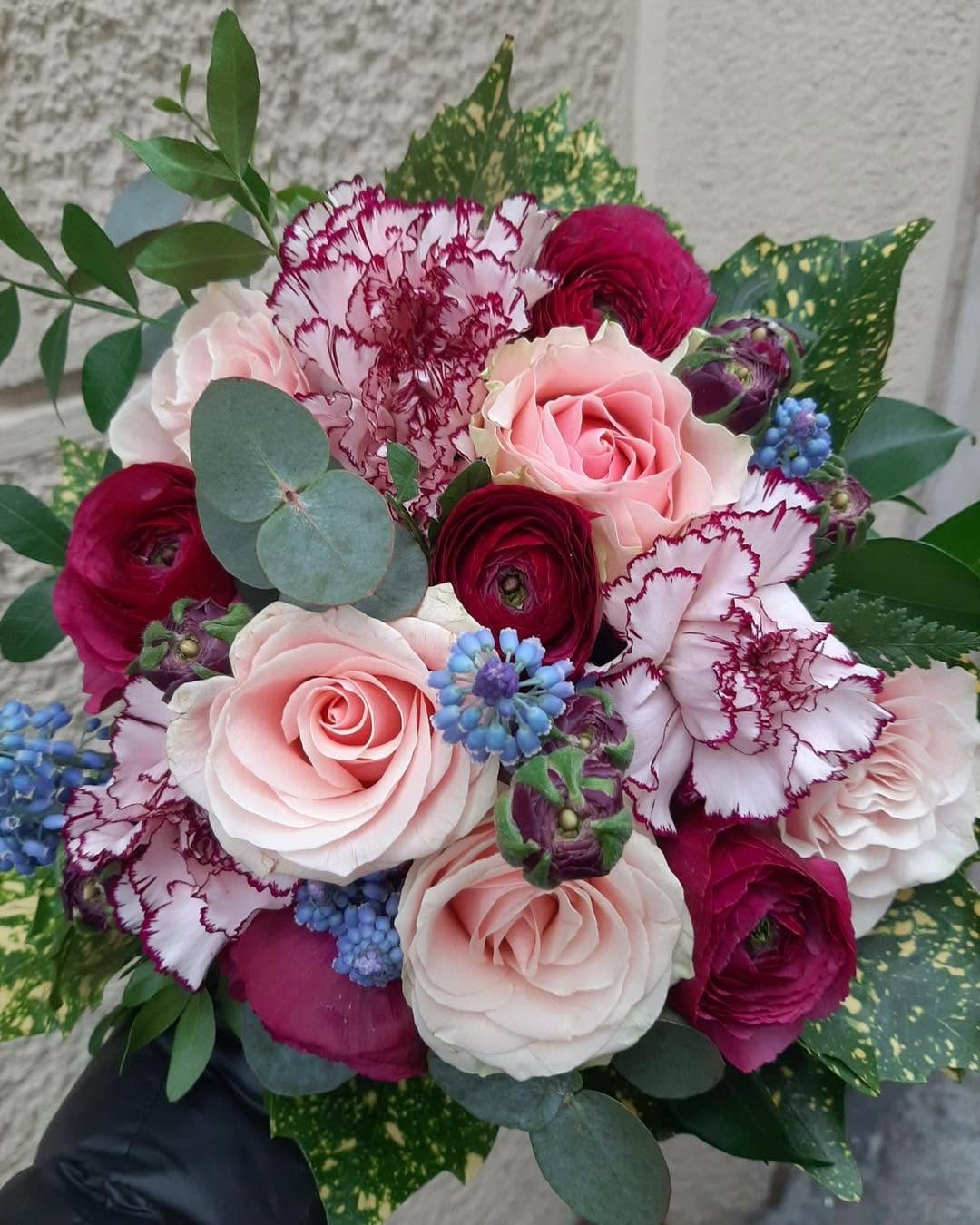 Bouquet di rose, ranuncoli e garofani nei toni del rosa e del rosso